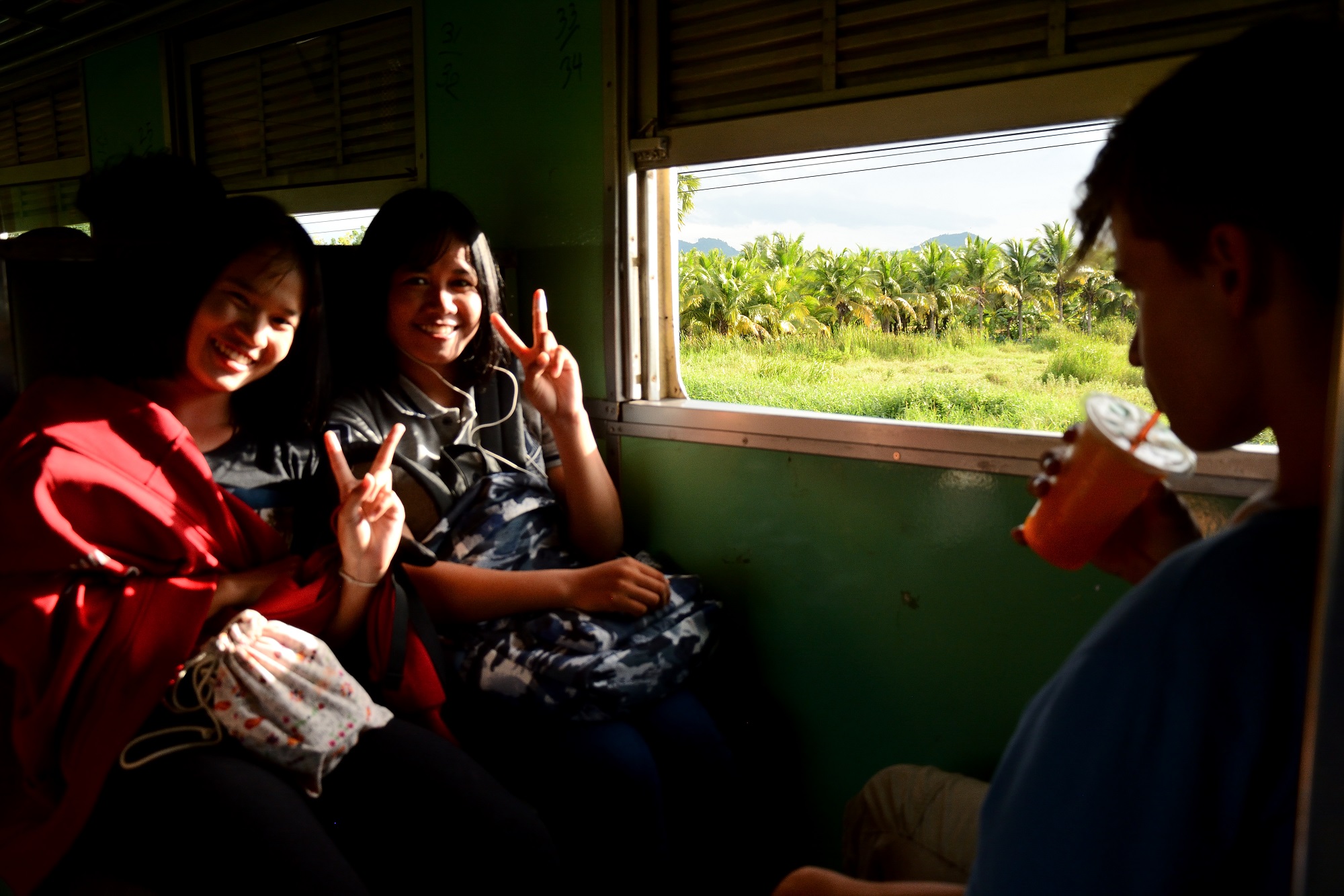 Thai girls on board the train heading south